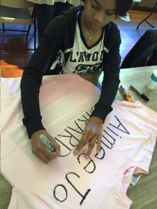 An Overbrook PC volunteer writes the name of a person who was killed by gun violence in Philadelphia in 2014.